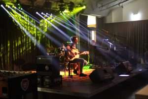 OpenStage - Einzelner Musiker sitzt im Scheinwerferlicht auf der Bühne